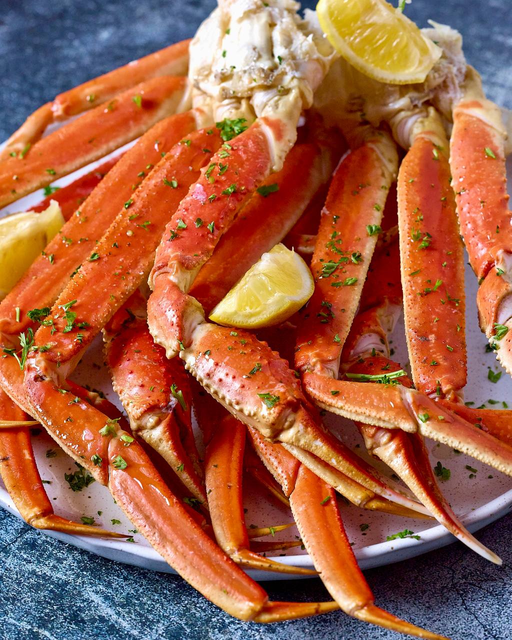 Fresh snow crab legs on a plate with lemon at Pirate's Table