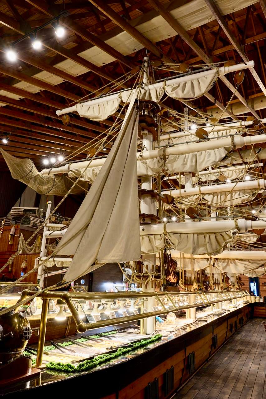 Inside the 105-foot pirate ship buffet at Pirate's Table — masts, sails, and the seafood line